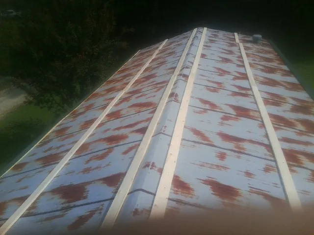 Rusted metal roof panels with new wood purlins before replacement — Storm Damage Roof Repair in Hinesville by Roofing Brothers