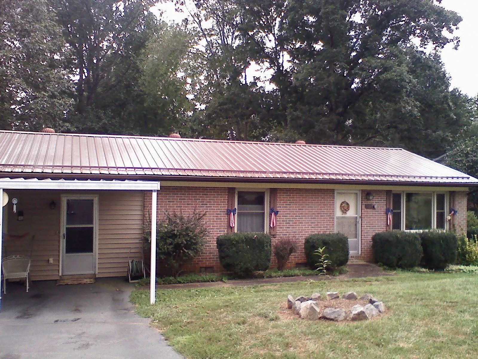 Bronze metal roof and carport on a brick ranch home — Roof Repair work by our crew in Hinesville