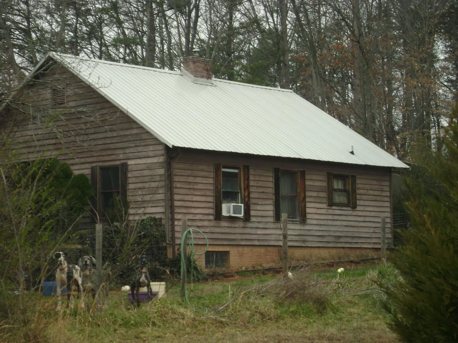 White metal roof on an old wood sided farmhouse, from a Asphalt Shingle Roof Repair job in Hinesville
